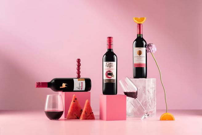 Botellas de vino sobre fondo rosado